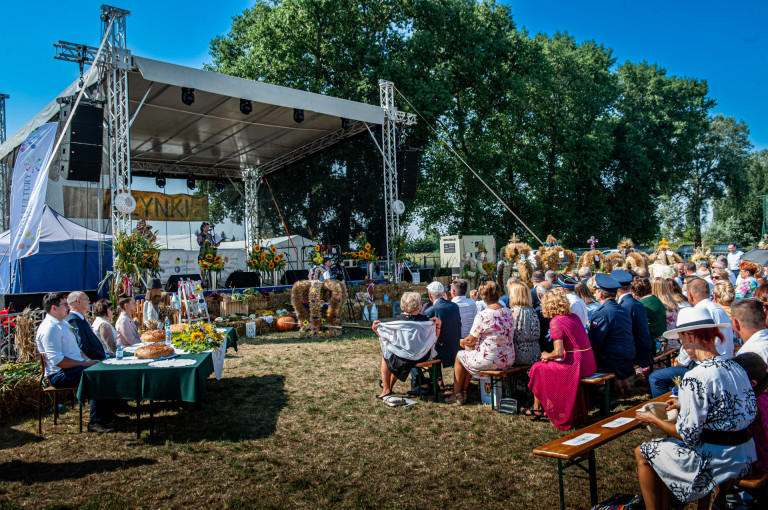 Scena ustawiona jest w plenerze. Przed sceną siedzą goście.