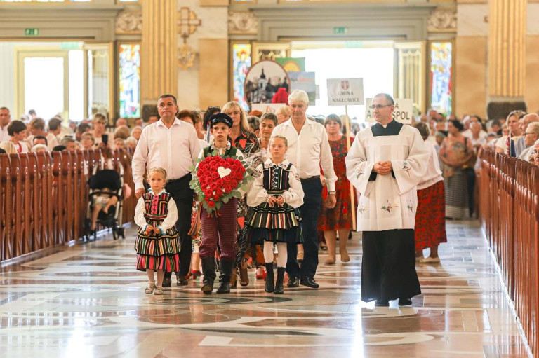 Korowód wchodzi do sanktuarium. Korowód prowadzi troje dzieci w ludowych strojach wraz z księdzem.