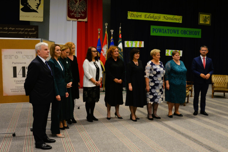 Dyrektorki i dyrektorzy szkół oraz iinych placówek stoją obok siebie w rzędzie.