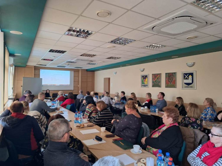 Kilkadziesiąt osób ogląda prezentację multimedialną. Kobieta prowadząca szkolenie siedzi.
