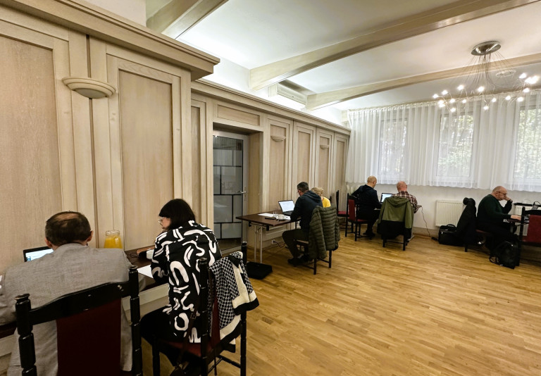Uczestnicy szkolenia siedzą w parach przed laptopami.