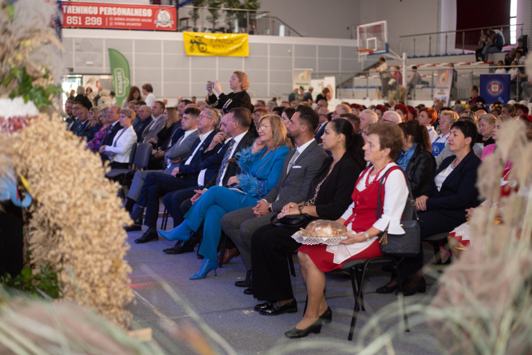 Liczna widownia siedzi w hali sportowej.