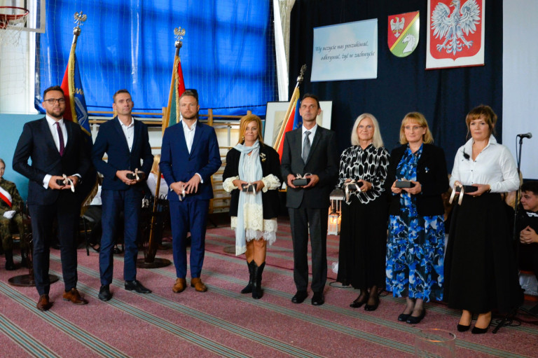 Grupa ludzi trzyma upominki.