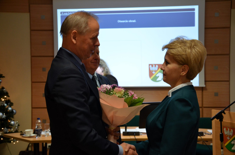 Mężczyzna wręcza kobiecie bukiet kwiatów.