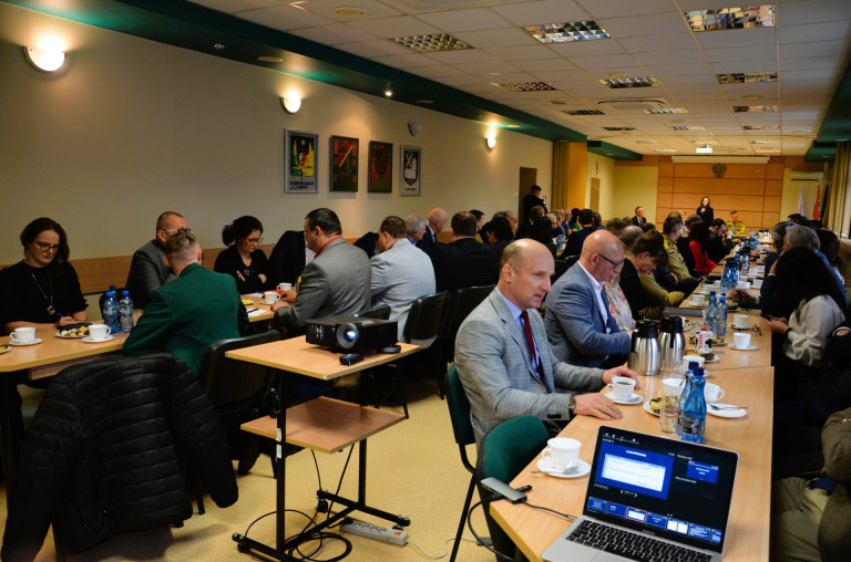Ludzie siedzący w sali konferencyjnej.