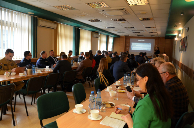 Ludzie w sali konferencyjnej oglądający prezentację.